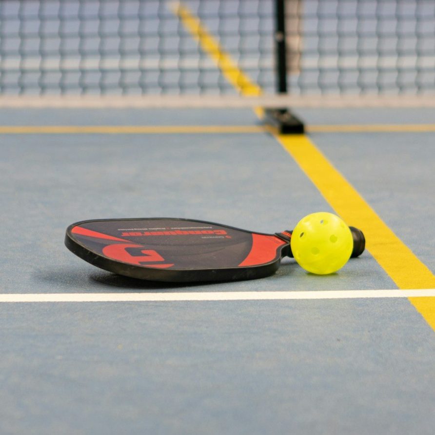 a tennis racket and ball on a tennis court